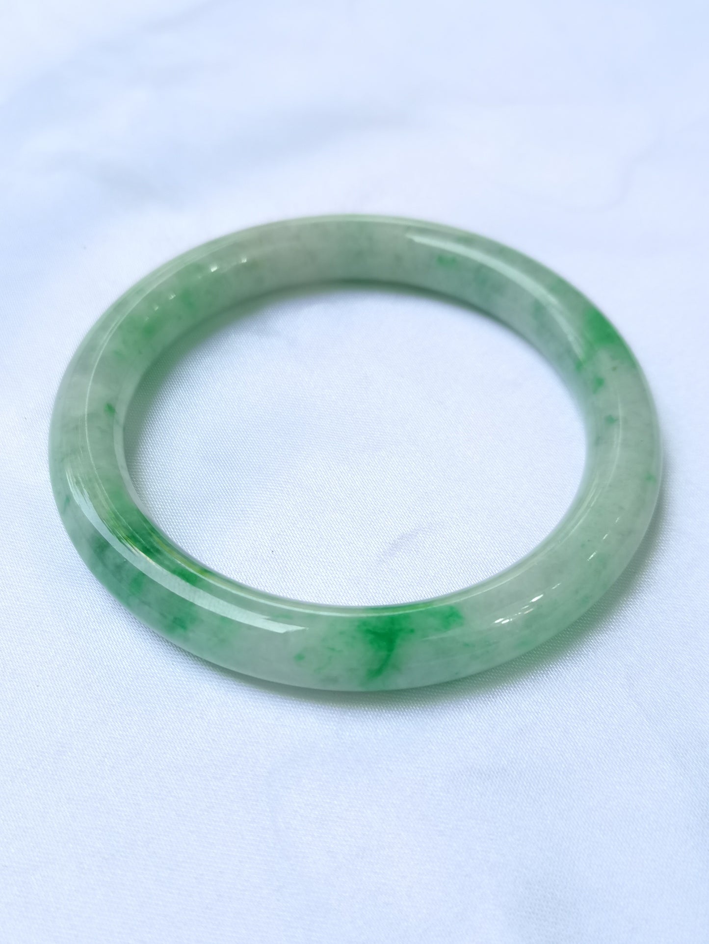 GUARDIAN | JAYDE Untreated Grade-A Jadeite Bangle in Pastel Green with patches of Vibrant Green (56.5mm Round)