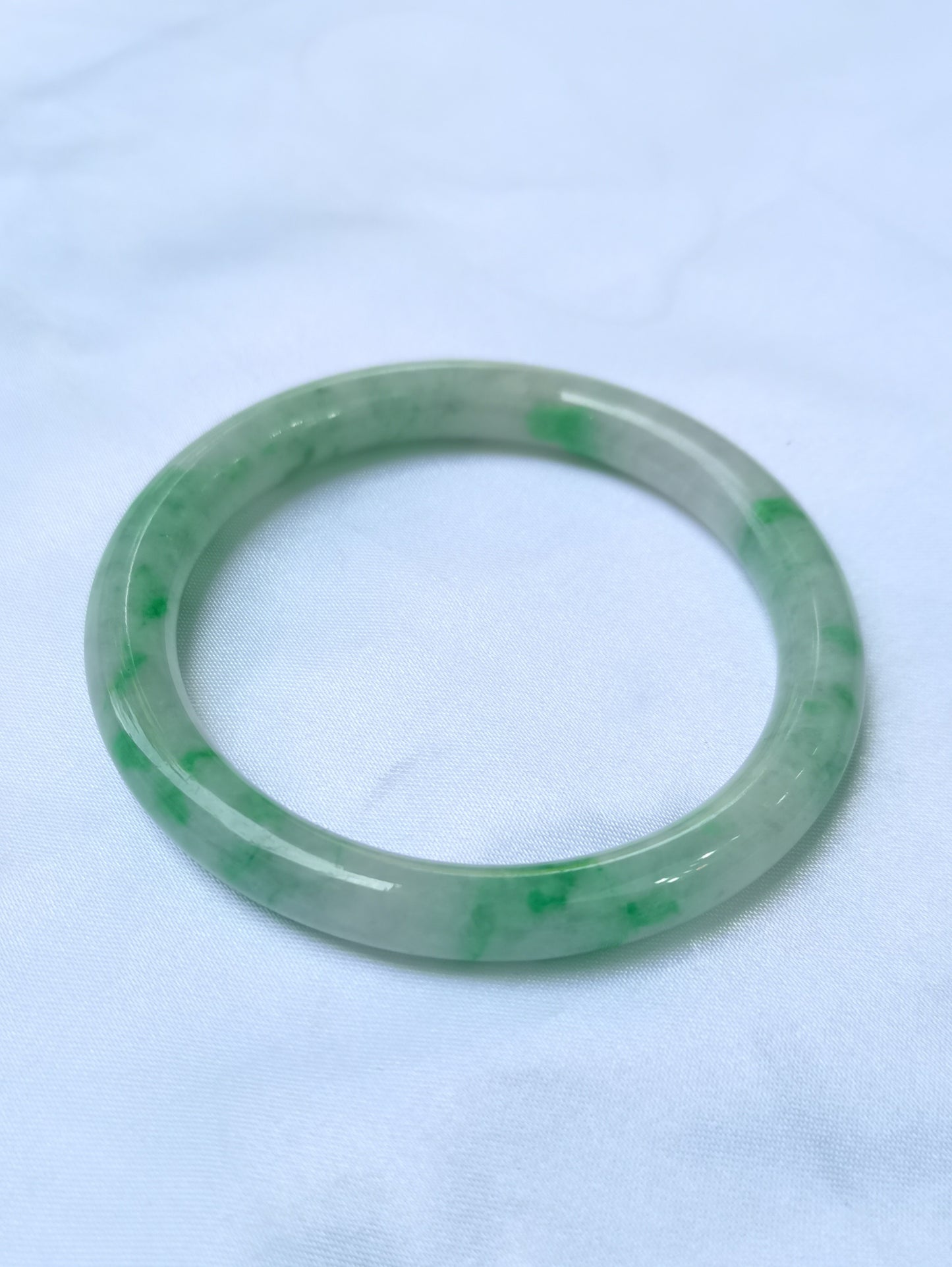 GUARDIAN | JAYDE Untreated Grade-A Jadeite Bangle in Pastel Green with patches of Vibrant Green (55.8mm Round)